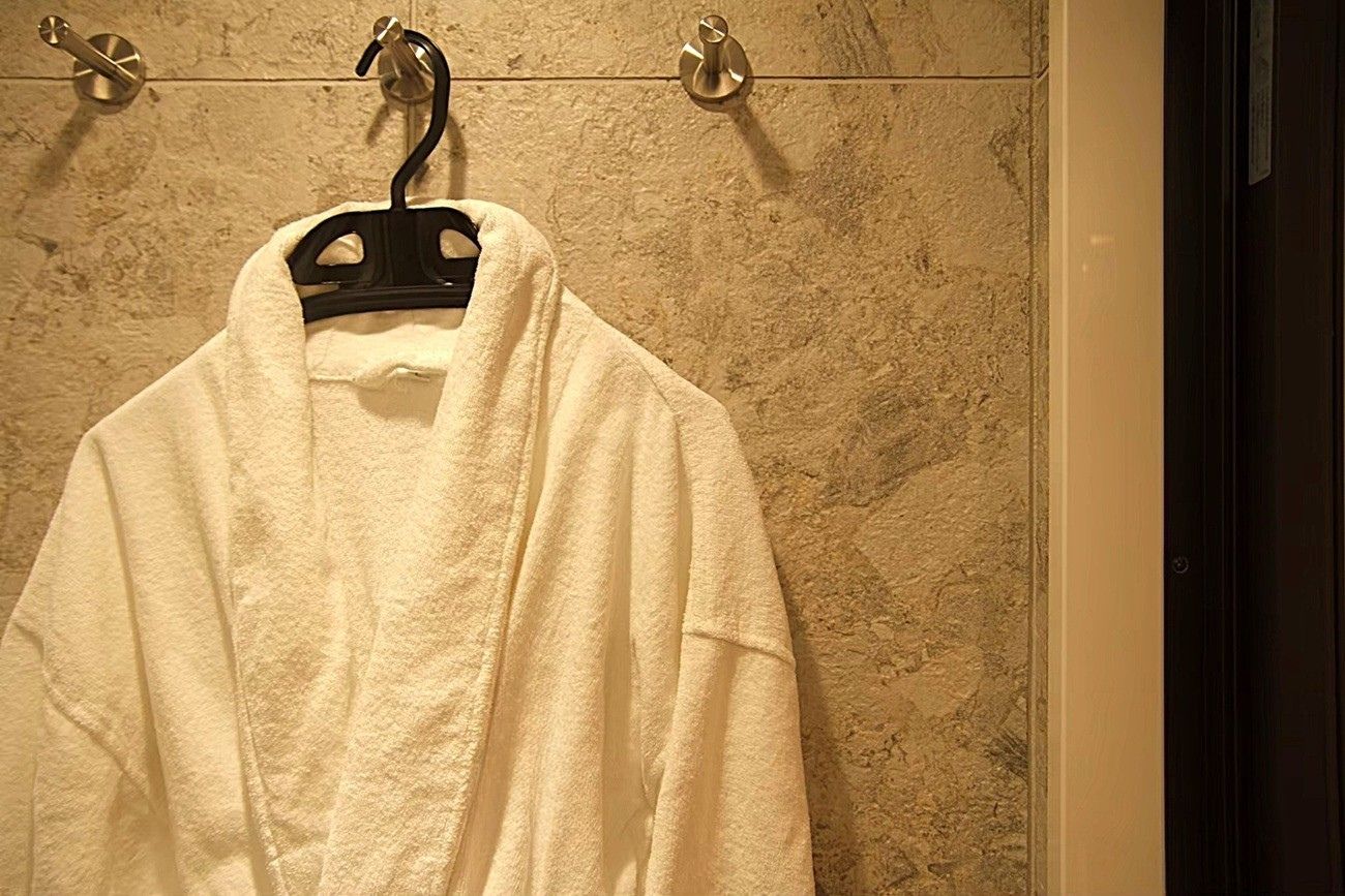 大阪市城東区M邸|洗面所リノベーション(石目調タイルの壁とバスローブ、ホテルライクな演出)